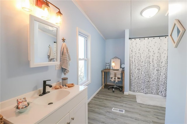 full bathroom with vanity, wood finished floors, visible vents, and ornamental molding