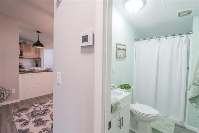 full bathroom with visible vents, toilet, a shower with curtain, wood finished floors, and vanity