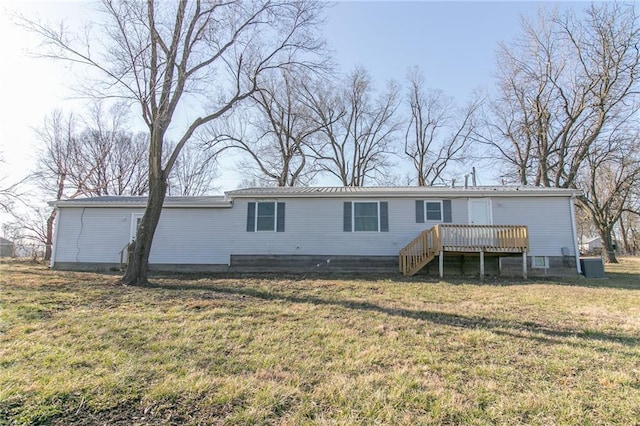 rear view of property featuring a wooden deck, a lawn, and stairway