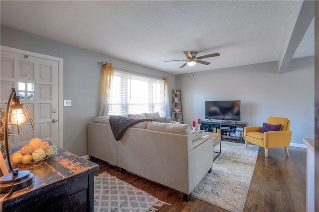 living area with a ceiling fan, wood finished floors, baseboards, and a textured ceiling