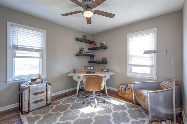 office space featuring a wealth of natural light, visible vents, baseboards, and wood finished floors