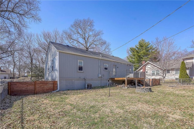 rear view of property featuring a fenced backyard, a lawn, and a deck