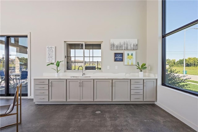 bar with baseboards and a sink