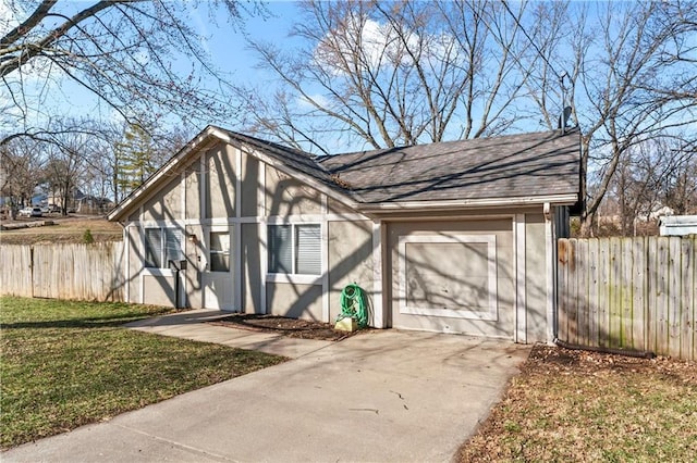 exterior space featuring a garage, concrete driveway, stucco siding, and fence