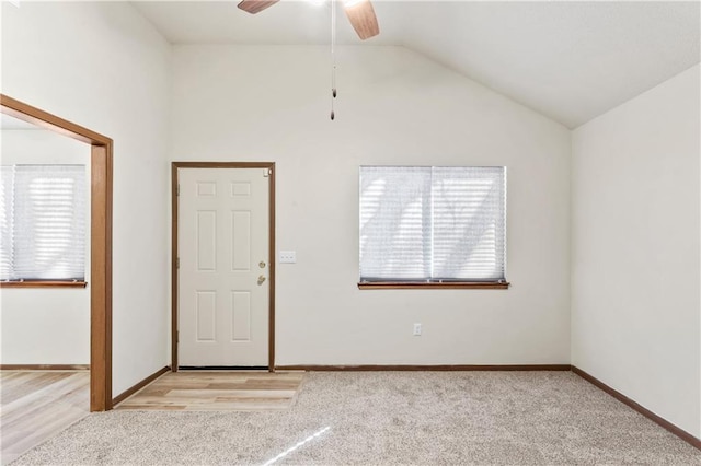 foyer with vaulted ceiling, plenty of natural light, light colored carpet, and baseboards