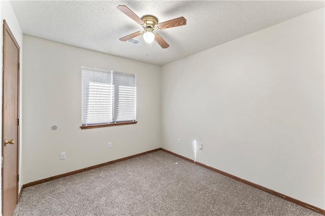 empty room featuring a ceiling fan, visible vents, carpet floors, baseboards, and a textured ceiling