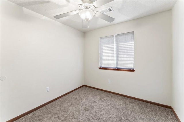 unfurnished room with visible vents, a textured ceiling, carpet, baseboards, and ceiling fan