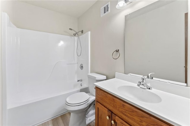 bathroom with visible vents, toilet, shower / tub combination, wood finished floors, and vanity