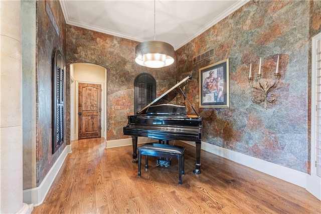 sitting room featuring visible vents, wood finished floors, and ornamental molding