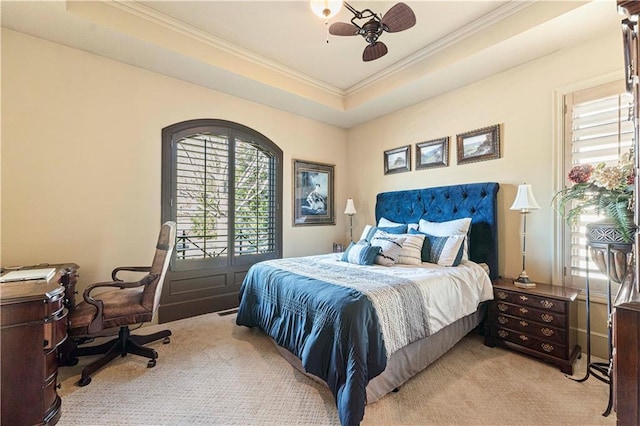 bedroom with a raised ceiling, light colored carpet, ceiling fan, and crown molding