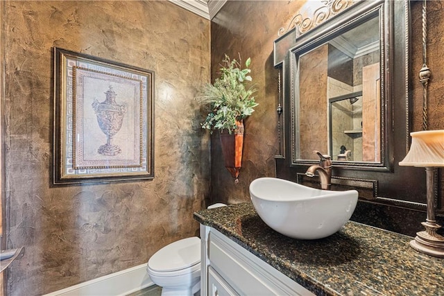 bathroom featuring baseboards, toilet, ornamental molding, vanity, and a shower