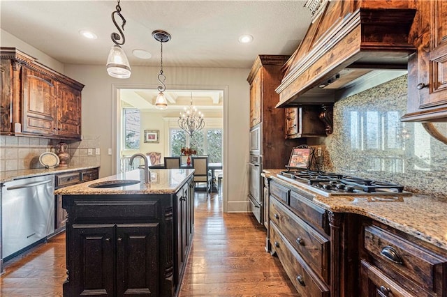 kitchen featuring light stone countertops, dark wood finished floors, custom exhaust hood, a sink, and stainless steel appliances