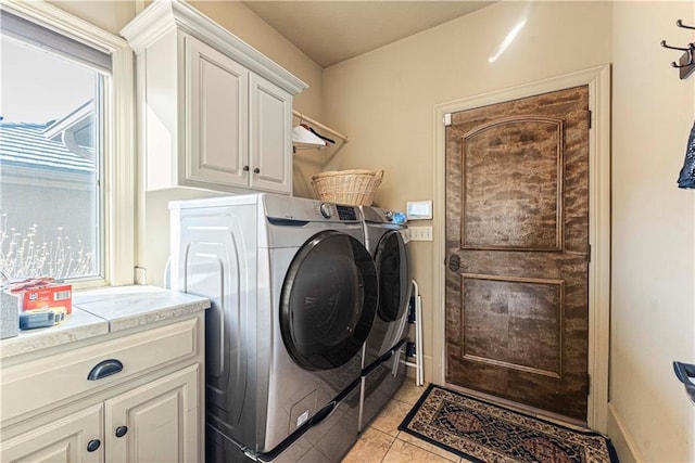 laundry room with cabinet space, light tile patterned floors, separate washer and dryer, and baseboards