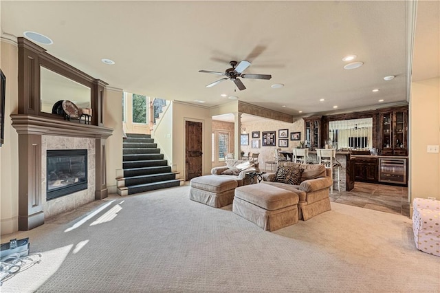 living room featuring wine cooler, stairway, a tiled fireplace, decorative columns, and recessed lighting