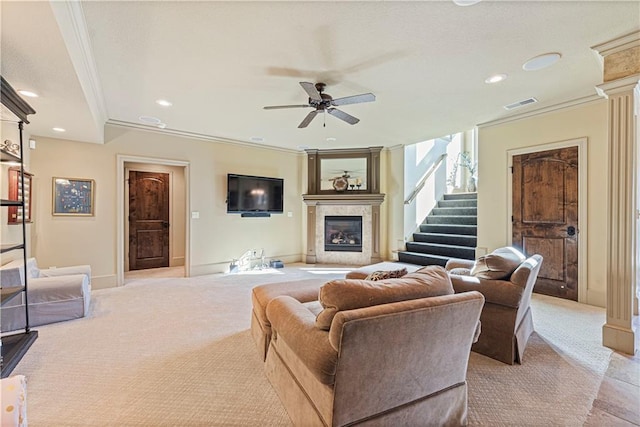 living room with light colored carpet, a tile fireplace, stairs, and ornamental molding