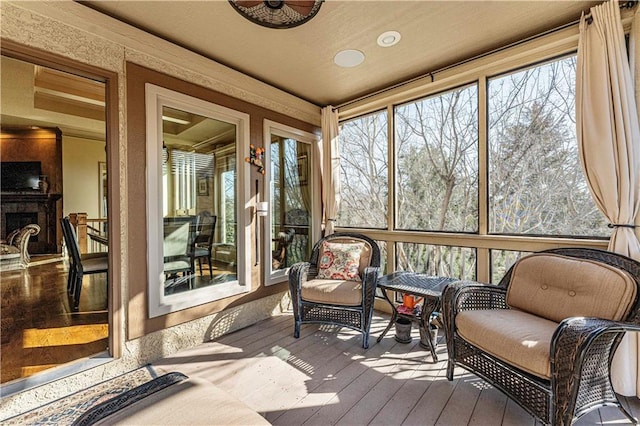 sunroom / solarium featuring a fireplace with raised hearth