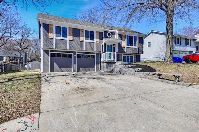 raised ranch with a residential view, an attached garage, concrete driveway, and fence