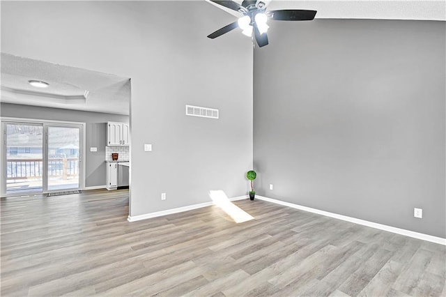 unfurnished living room with visible vents, baseboards, light wood-type flooring, and a ceiling fan