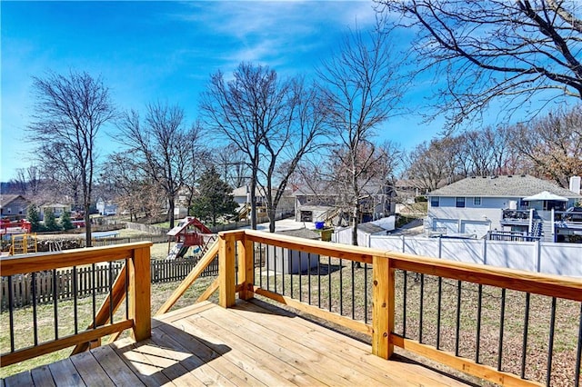 deck with a residential view, fence, and a playground