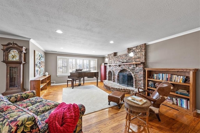 living area featuring baseboards, wood finished floors, a fireplace, and crown molding