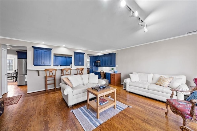 living room with dark wood-type flooring, crown molding, recessed lighting, and visible vents