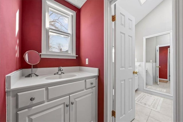 bathroom featuring tile patterned floors, vanity, and vaulted ceiling