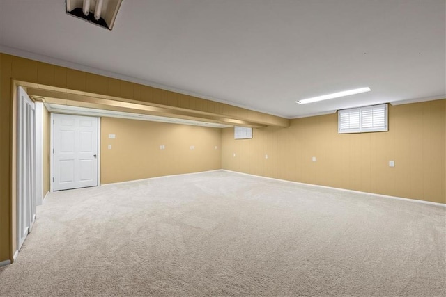 below grade area with carpet and ornamental molding