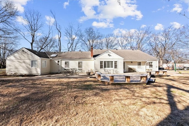 back of house with a patio, a yard, and a chimney