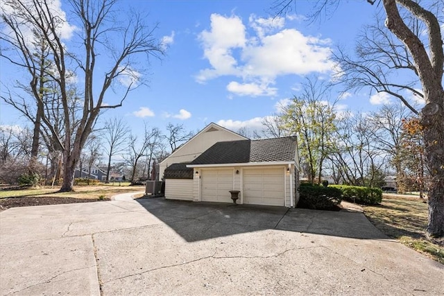 view of property exterior featuring a garage, concrete driveway, and roof with shingles