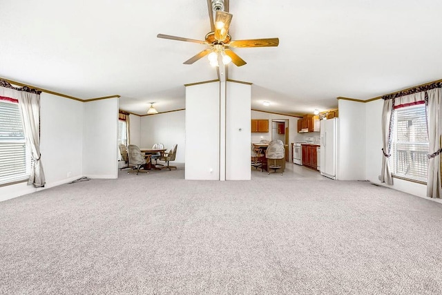 unfurnished living room featuring light carpet, crown molding, ceiling fan, and vaulted ceiling