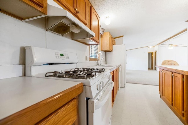 kitchen with under cabinet range hood, brown cabinets, light countertops, and white range with gas stovetop