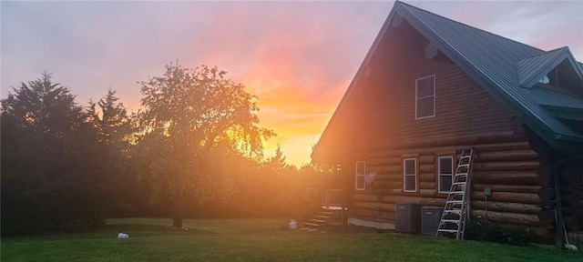 view of home's exterior featuring metal roof, a barn, and a lawn