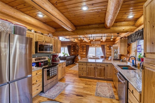 kitchen with light wood-style flooring, beamed ceiling, appliances with stainless steel finishes, and a sink