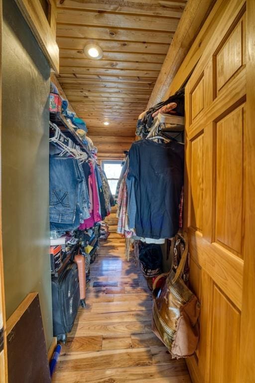 walk in closet with wood finished floors