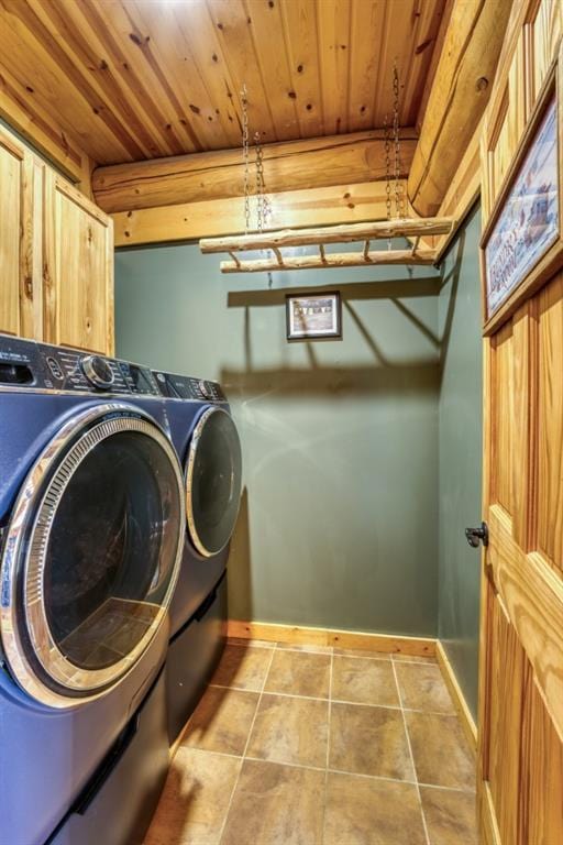 clothes washing area with washer and dryer, baseboards, wood ceiling, and tile patterned floors