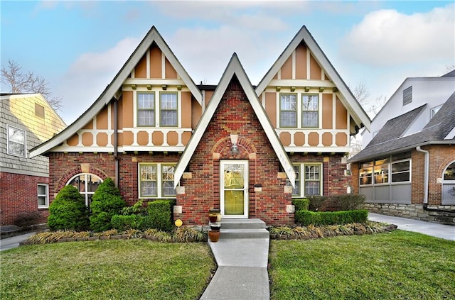 english style home with brick siding and a front lawn