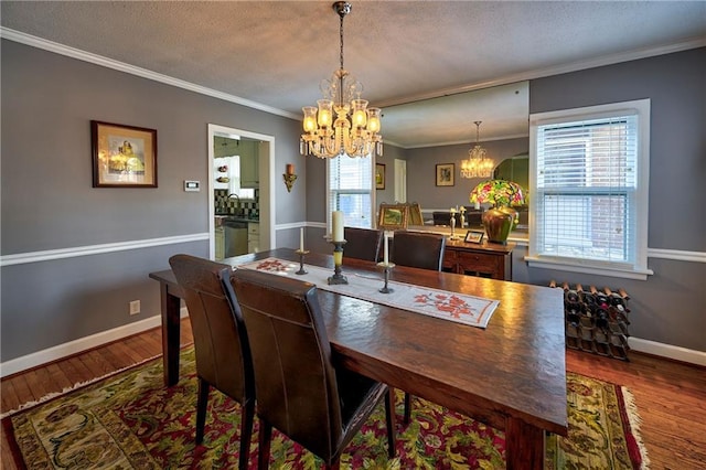 dining room with a notable chandelier, wood finished floors, crown molding, and a textured ceiling