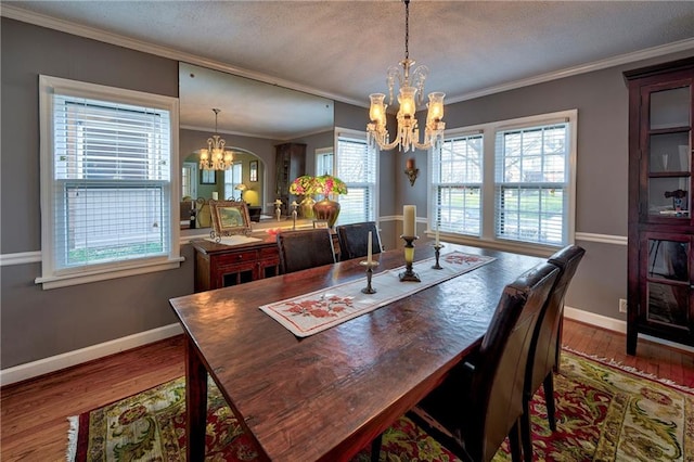 dining area with a notable chandelier, a healthy amount of sunlight, and wood finished floors