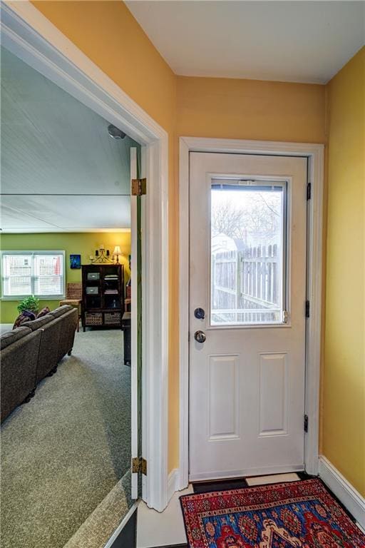 entryway with baseboards and carpet floors