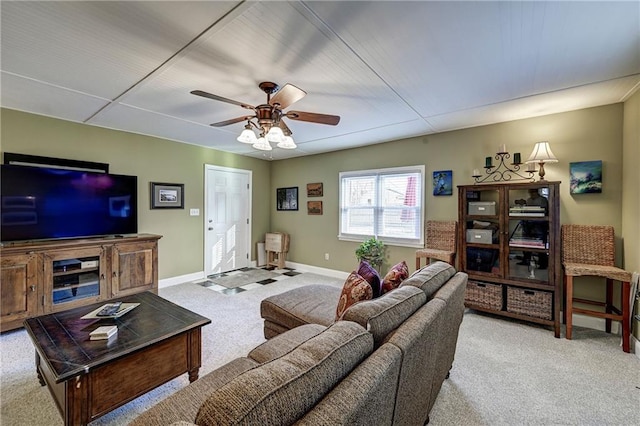 living room featuring carpet flooring, baseboards, and ceiling fan