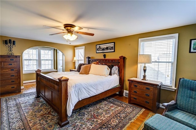 bedroom featuring ceiling fan, baseboards, and wood finished floors