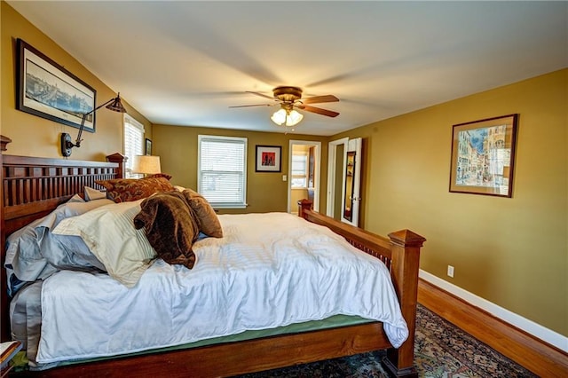 bedroom featuring a ceiling fan, baseboards, and wood finished floors