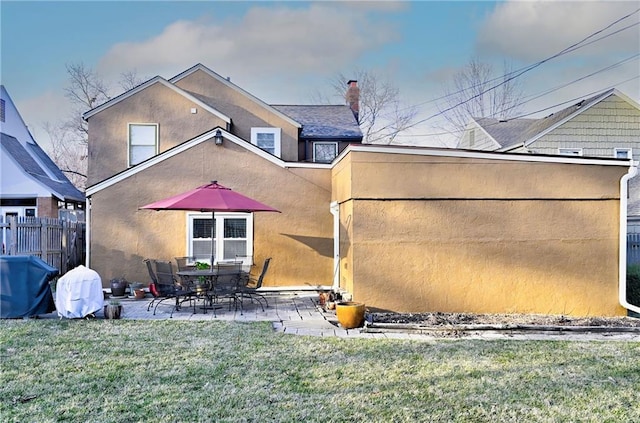 back of house with a patio, a yard, fence, and stucco siding