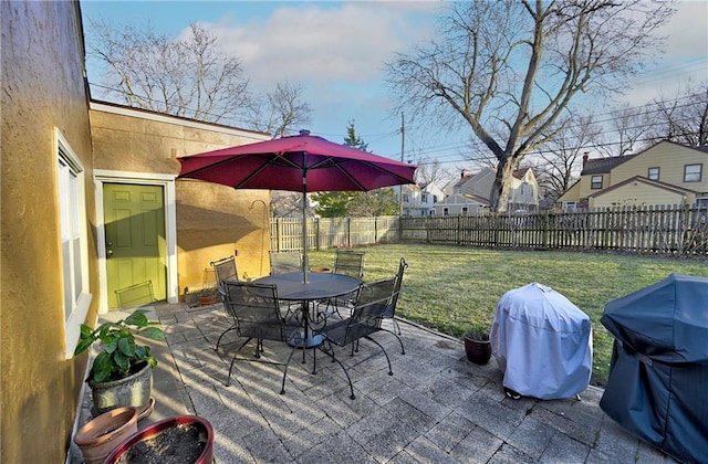 view of patio featuring grilling area, outdoor dining space, and a fenced backyard