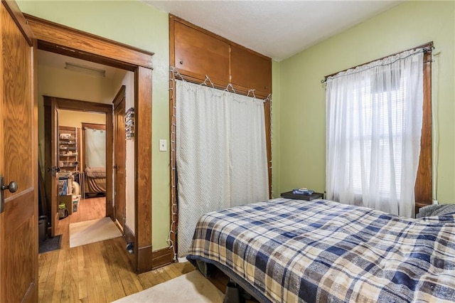 bedroom featuring multiple windows and wood finished floors