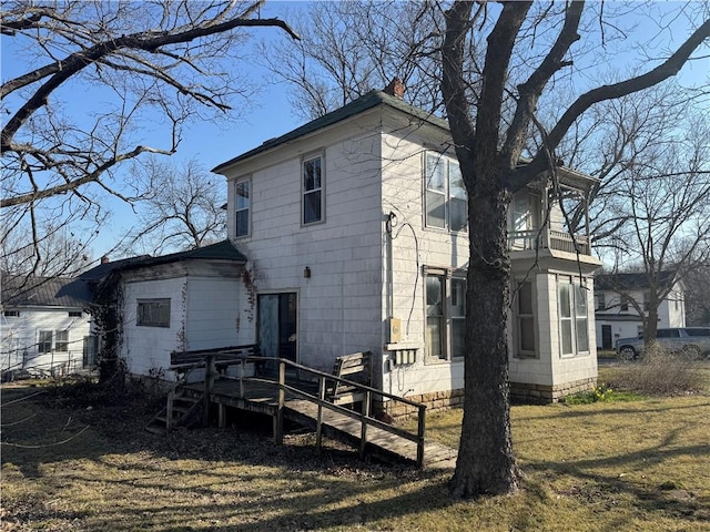 rear view of property with a deck and a chimney