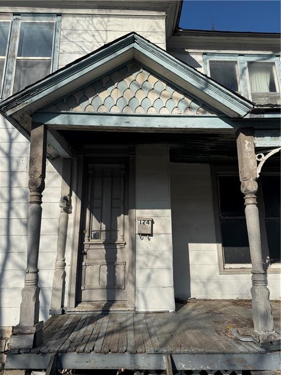 doorway to property featuring a tile roof and a porch