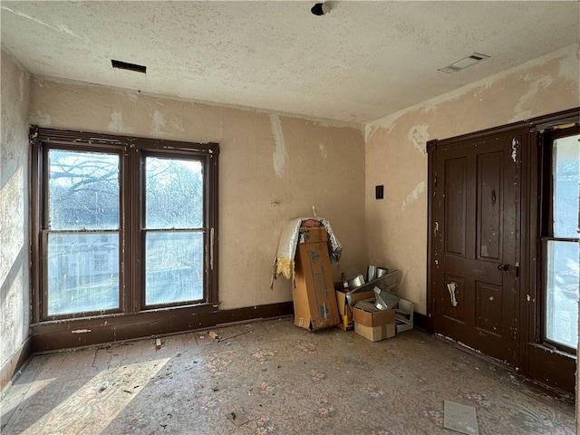 unfurnished room featuring visible vents and a textured ceiling