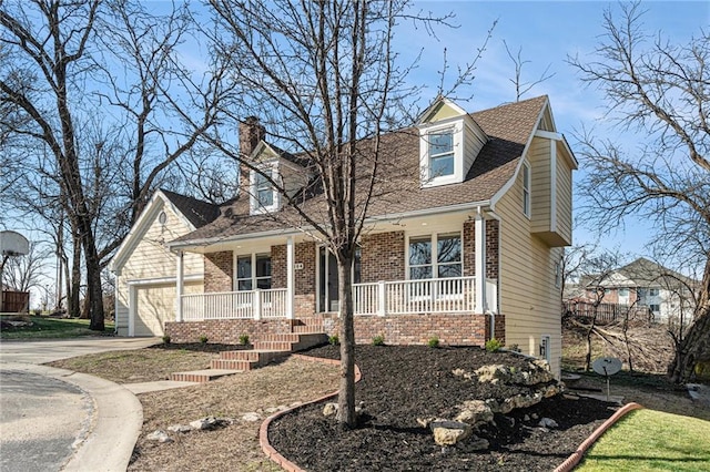 cape cod home with roof with shingles, driveway, a porch, a chimney, and brick siding