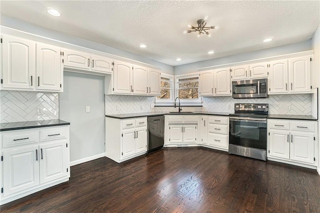 kitchen with a sink, dark countertops, dark wood-style flooring, and stainless steel appliances